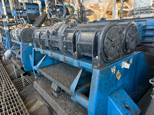 A shale shaker on an oil rig is a vibrating screen that separates large drilled solids, or cuttings, from the drilling fluid, or mud.