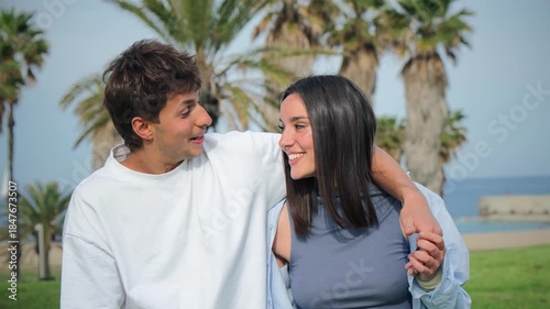 A joyful couple enjoying a delightful moment as they walk closely together, sharing smiles and laughter, embodying the essence of love and connection in their relationship during a sunny day.