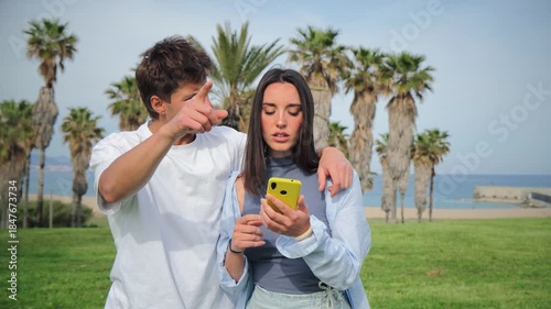 A young couple sharing a tender moment as they look at their smartphone, absorbed in the content they are viewing. Their connection is evident as they explore something interesting together.