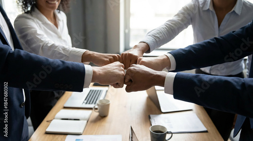 Cropped of a business teams hands clasped together in a fist bump, showcasing their camaraderie and unity. The image captures the essence of teamwork