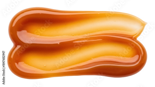 Photos Isolated streak of golden caramel sauce, sweet dessert topping for baked goods,
