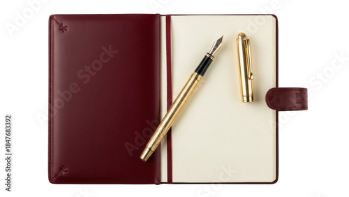 Isolated stationery set of bound journal with gold fountain pen and cap atop open pages