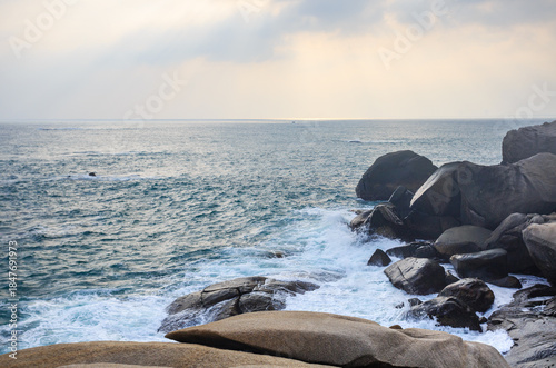 The scenery of Stone Park in Hainan, China, features emerald-green seawater crashing against the rocks, creating beautiful waves.