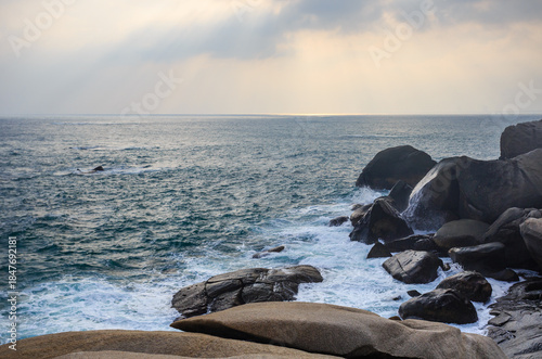 The scenery of Stone Park in Hainan, China, features emerald-green seawater crashing against the rocks, creating beautiful waves.