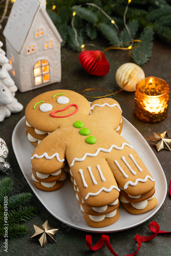 Christmas honey cake Gingerbread man on a white plate. New year festive dessert. Selective focus