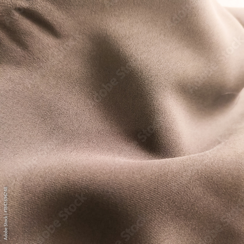 Neutral brown gray textile texture with flowing fabric folds