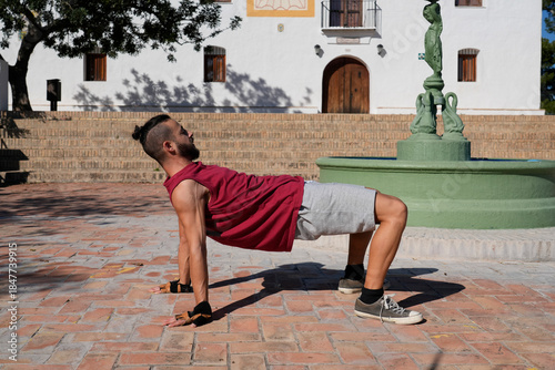 Man breakdancing a handstand freeze on urban bricks