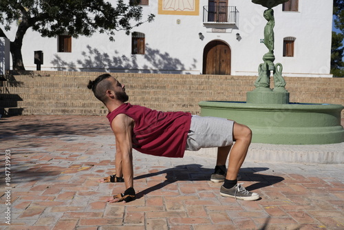 Man breakdancing a handstand freeze on urban bricks