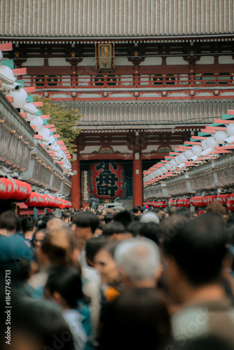 Huge crowds of tourists walking down Nakamise shopping street towards the Hozomon Gate at Senso-ji Temple