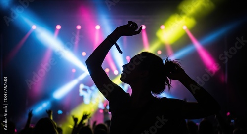 Captivating silhouette of a woman immersed in the energy of a vibrant concert with dazzling stage lighting