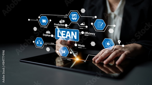 A professional interacts with a digital tablet showcasing lean management principles through holographic icons, emphasizing efficiency and waste reduction in business practices. Tessel