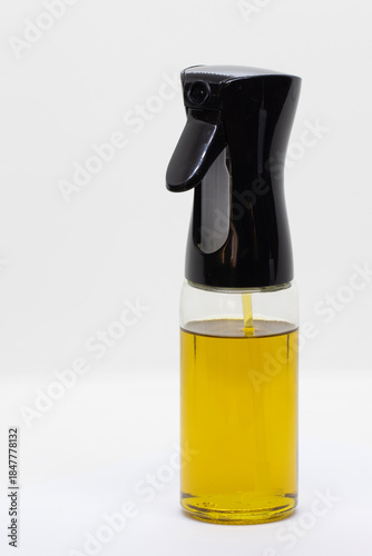 Olive oil in a spray glass bottle, isolated on a white background