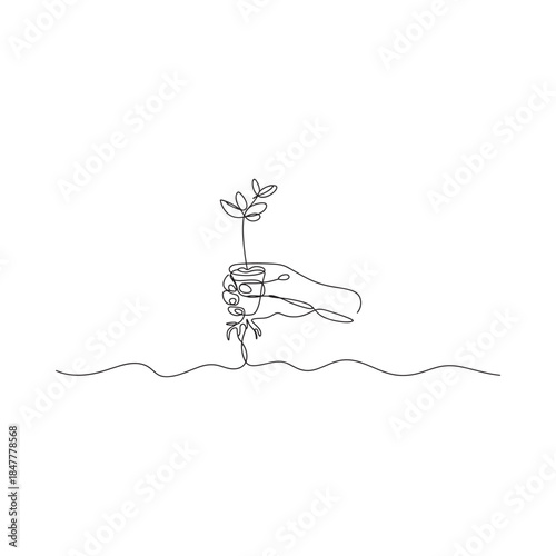 A delicate hand nurturing a small plant with roots in the soil