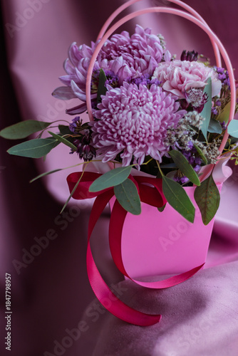 Floral arrangement with chrysanthemums, calla, carnations and eucalyptus in pink purple tones