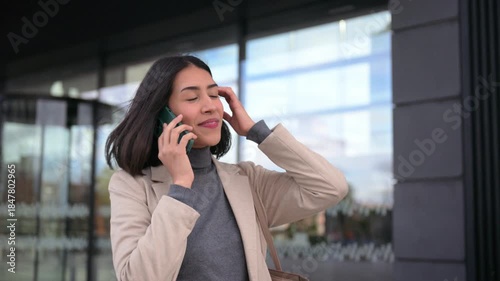 Young businesswoman talking on the phone while walking