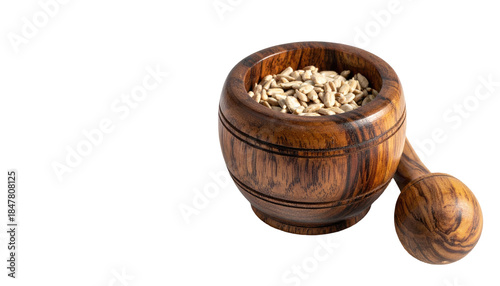 Wooden mortar and pestle filled with sunflower seeds, set against a stark black background