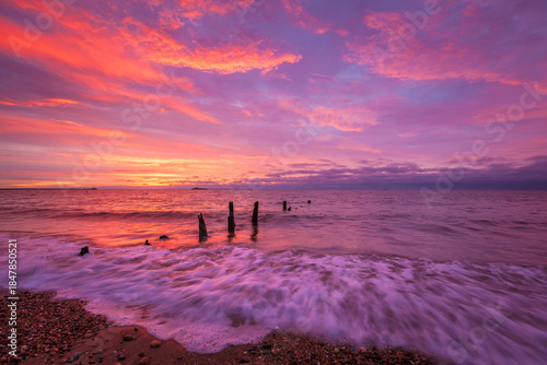 Crimson Display Colorful Purple and Pink Sunrise Over Ocean Waves