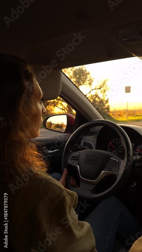 Driving sunset woman, traveling alone in a modern car on a highway road during golden hour light.