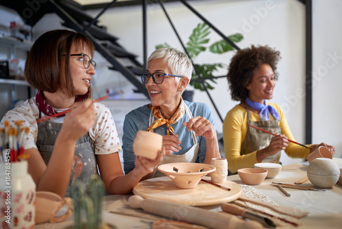 pottery making workshop . group of people painting pot with brushes. Creative, hobby ,activities concept