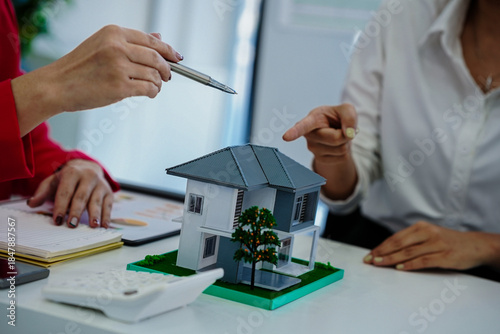 A real estate agent explained the insurance policy to a couple buying a new home, highlighting key terms and future investment during a meeting.
