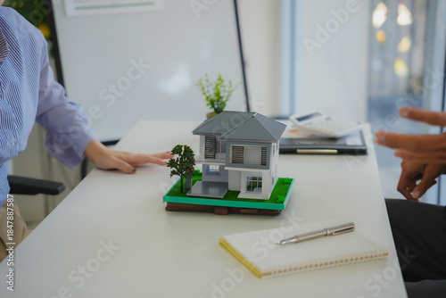 A real estate agent explained the insurance policy to a couple buying a new home, highlighting key terms and future investment during a meeting.