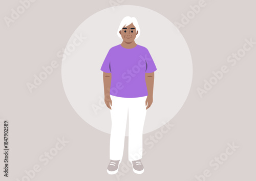 A joyful senior woman dressed in a bright boxy t-shirt stands confidently, She showcases her sense of style while radiating happiness in a simple, tranquil environment.