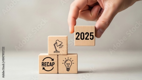 2025 Year in Review Business and Finance. Wooden blocks stacked with recap and idea icons under 2025, symbol of structured business evaluation.
