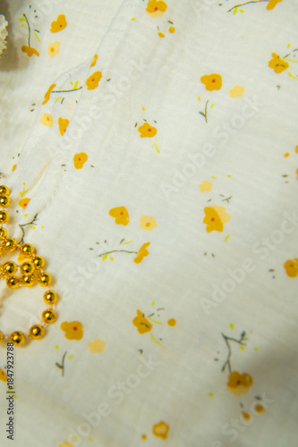 Fotografie Soft muslin fabric with a delicate yellow floral pattern, textile background