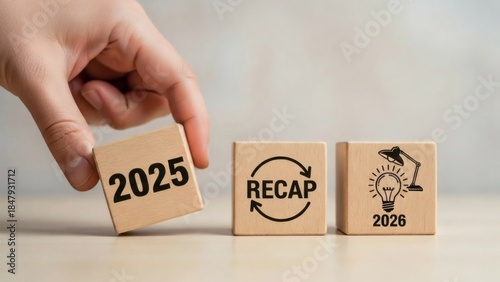 2025 Year in Review Business and Finance. Wooden blocks showing recap and idea moving toward 2026, symbol of business transition and growth.
