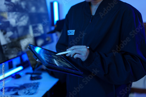 Security officers are checking the TV screen of the CCTV system.