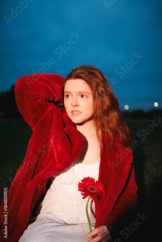 Red Haired Woman Holding Flower at Dusk