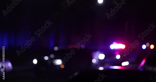 Abstracted illuminated night view of police units on a city street.