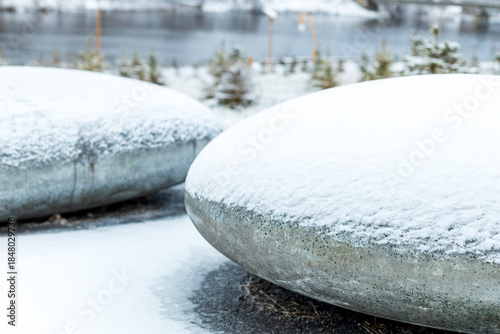 Two large, snow-covered rocks sit on a snowy ground