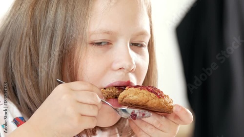Little girl eats homemade cookies with jam prepared with their own hands