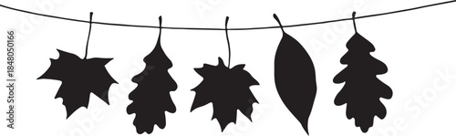  silhouette of Autumn leaves hanging on a string on a white background