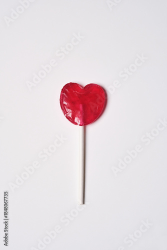 Heart Shaped Candy on a Stick in a Simple Setup on Plain Background