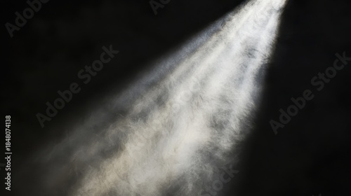 A single focused beam of bright light illuminates swirling particles in a dark atmosphere