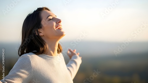 Woman embracing freedom and fresh air with arms outstretched and a smile on her face in an outdoor natural setting