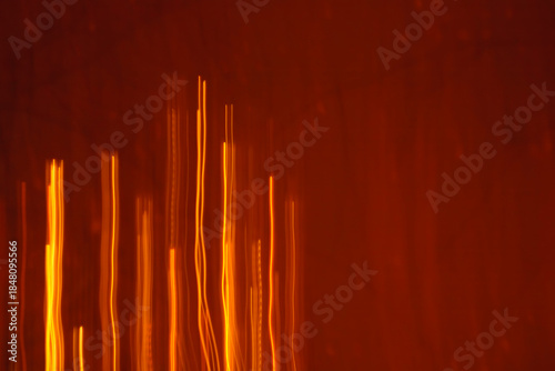 Abstract minimal orange vertical light lines. Sound equalizer or digital data flow texture on dark background.