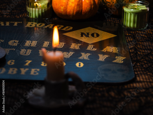 Candle burning with spirt board and pumpkins