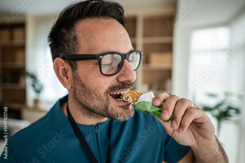 Fotografía Man enjoying healthy protein bar snack indoors