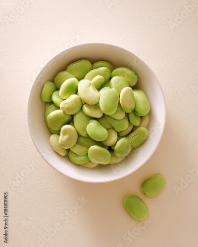 Wallpaper Mural A close-up of a bowl filled with vibrant green fava beans, showcasing their smooth texture and natural color, This image is ideal for culinary articles, health blogs, or plant-based recipe books, Torontodigital.ca