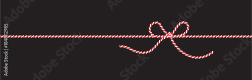 Red and white striped ribbon tied in a decorative bow on black