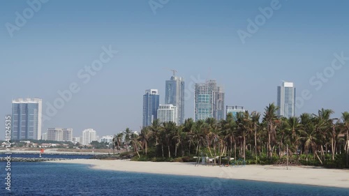 Sail along Eco Park island beach in Dubai with skyline view of modern skyscrapers and waterfront in United Arab Emirates