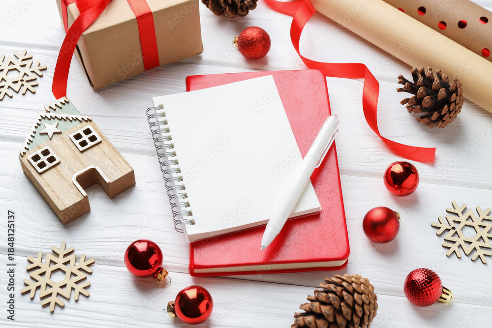 Obraz premium New Year aims. Blank planner, pen and festive decor on white wooden table