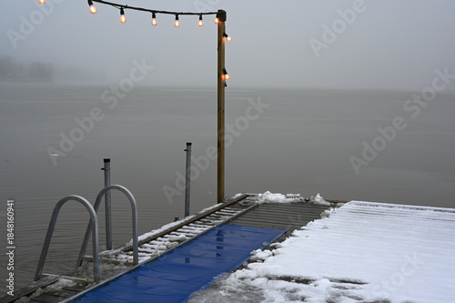 a wooden pier stretching into a calm, fog-covered lake