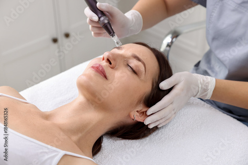 Konstfotografi Woman undergoing microneedling procedure in beauty salon, closeup