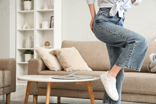 Young woman with hemorrhoids and paper thumbtack on table at home