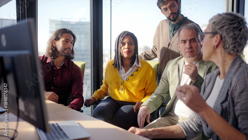 Fotografie Diverse group gathers around a screen for a collaborative discussion as a middle