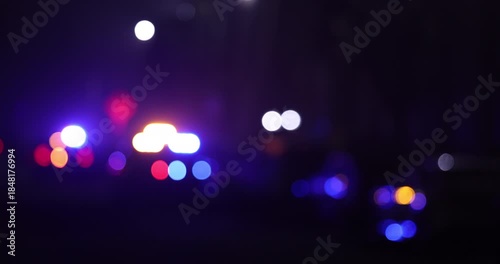 Abstracted illuminated night view of police units on a city street.